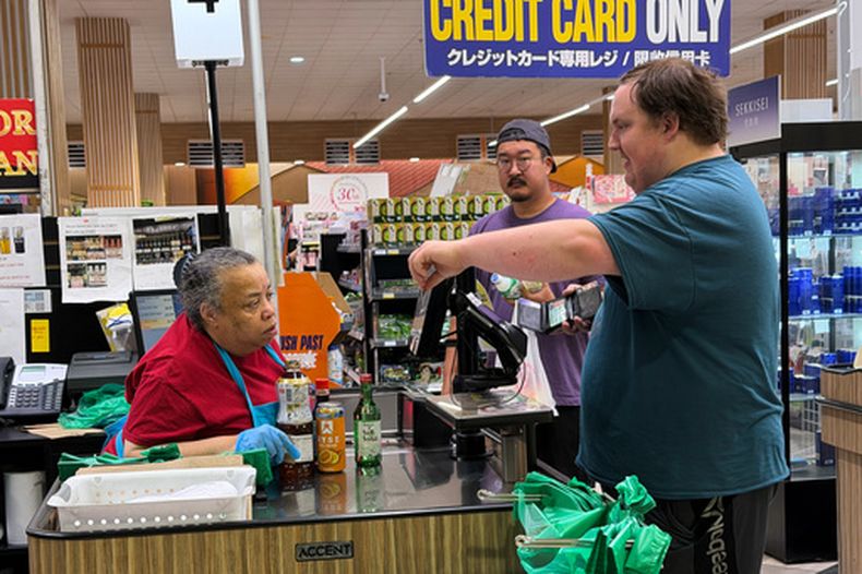 Un empleado revisa la tarjeta de identificación de un cliente antes de registrar una compra de alcohol en una tienda de comestibles en Arlington Heights, Illinois, el lunes 6 de julio de 2026. (AP Foto/Nam Y. Huh)