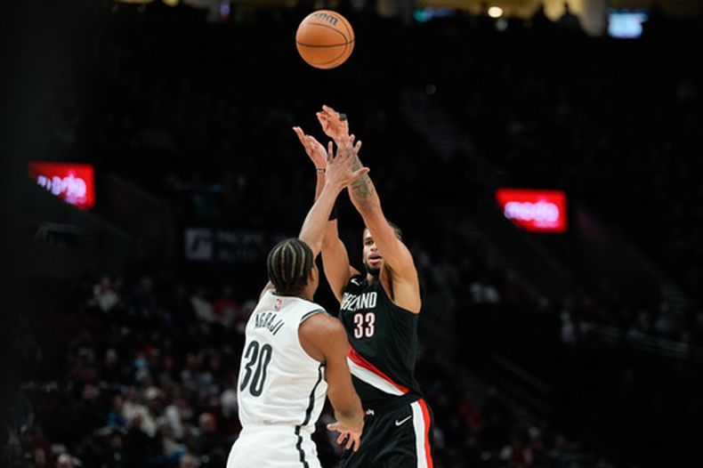 Toumani Camara (33), de los Trail Blazers de Portland, dispara sobre Ochai Agbaji (30), de los Nets de Brooklyn, durante la segunda mitad del juego de baloncesto de la NBA, el lunes 23 de marzo de 2026, en Portland, Oregon. (AP Foto/Jenny Kane)