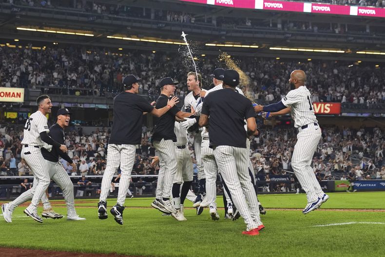 Ryan McMahon de los Yankees de Nueva York celebra con sus compañeros su sencillo remolcador de la victoria en la 11ma entrada ante los Rays de Tampa Bay el miércoles 30 de julio del 2025. (AP Foto/Frank Franklin II)