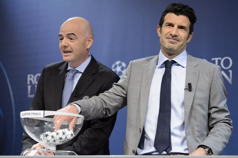 Luis Figo se apresta a sacar una bola del bollillero durante el sorteo de los cuartos de final de la Liga de Campeones el 21 de marzo del 2014 en Nyon, Suiza. A su lado aparece el secretario general de la UEFA Gianni Infantino. (AP Photo/Keystone,Laurent