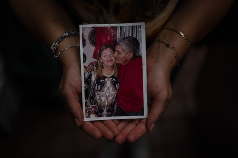 Kelly Granado, cuyos padres, Marina y Jesús, murieron en los terremotos del 24 de junio en Venezuela, sostiene una foto de ellos en su restaurante en el centro de Los Ángeles, martes 25 de agosto de 2026. (Foto AP/Jae C. Hong)