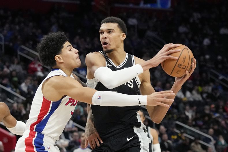 Victor Wembanyama, pívot de los Spurs de San Antonio, controla el balón frente a Killian Hayes, de los Pistons de Detroit, el miércoles 10 de enero de 2024 (AP Foto/Carlos Osorio)
