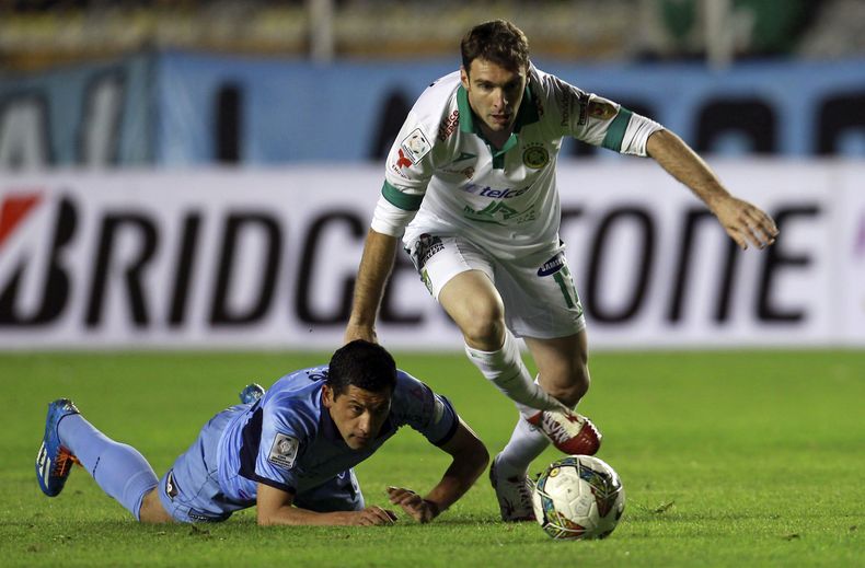 El argentino Mauro Boselli, del Le&oacute;n de M&eacute;xico, se lleva el bal&oacute;n mientras cae Walter Flores, del Bol&iacute;var, en un partido de la Copa Libertadores disputado el mi&eacute;rcoles 19 de febrero de 2014 en La Paz (AP Foto/Juan Karita