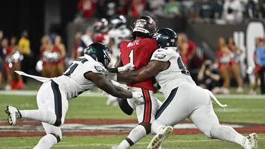 Jalen Carter (98) y Sydney Brown (21) de los Philadelphia Eagles tacklean a Rachaad White (1) de los Tampa Bay Buccaneers para forzar un fumble durante el juego de lunes por la noche, en Tampa, Florida. Lunes 25 de septiembre de 2023. (AP Foto/Jason Behnken)