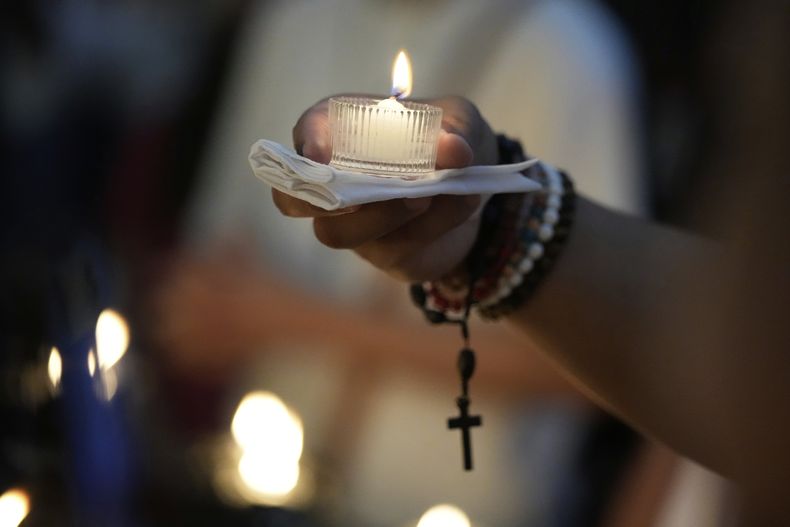Un hombre enciende una vela frente a un retrato del difunto papa Francisco, en la Catedral de Manila, Filipinas, el 22 de abril de 2025. (AP Foto/Aaron Favila)