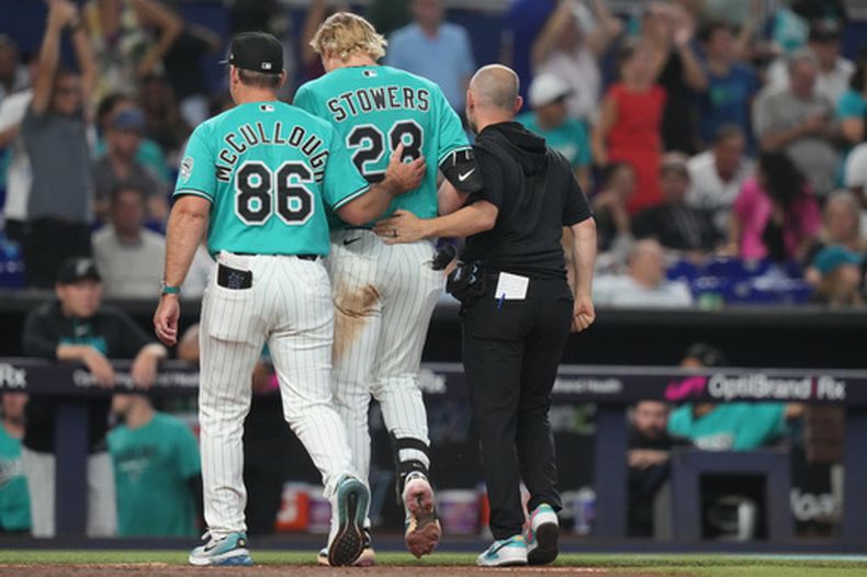 El jardinero de los Marlins de Miami, Kyle Stowers (28), es retirado del campo por el mánager Clayton McCullough (86) durante la quinta entrada de un partido de béisbol contra los Angelinos de Los Ángeles, el domingo 9 de agosto de 2026, en Miami. (Foto AP/Lynne Sladky)