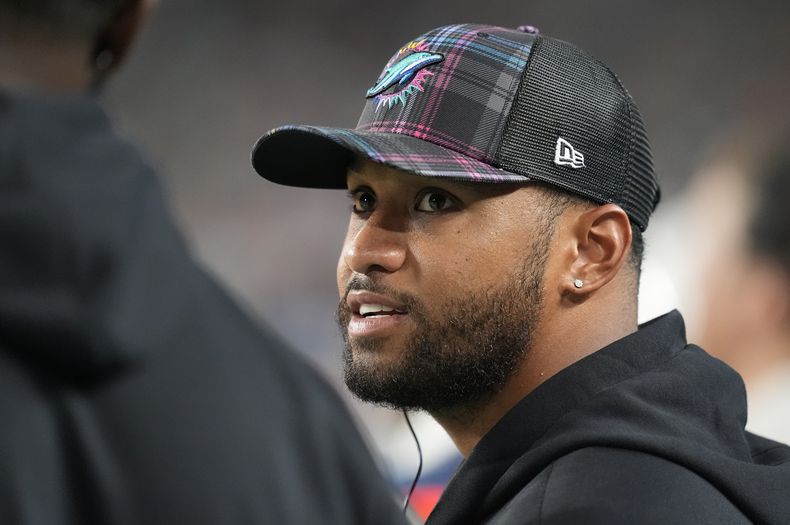 Tua Tagovailoa, quarterback de los Dolphins de Miami, habla con un compañero de equipo en la banca durante la segunda mitad del juego de la NFL contra los Titans de Tennessee Titans, el lunes 30 de septiembre de 2024, en Miami Gardens, Florida. (AP Foto/Rebecca Blackwell)