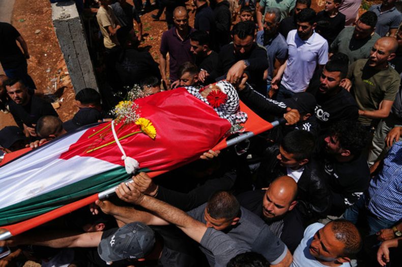 Familiares y amigos transportan el cuerpo del palestino Zakaria Qatousa durante su funeral en la ciudad de Deir Qaddis, en Cisjordania, el miércoles 13 de mayo de 2026. (Foto AP/Mahmoud Illean)