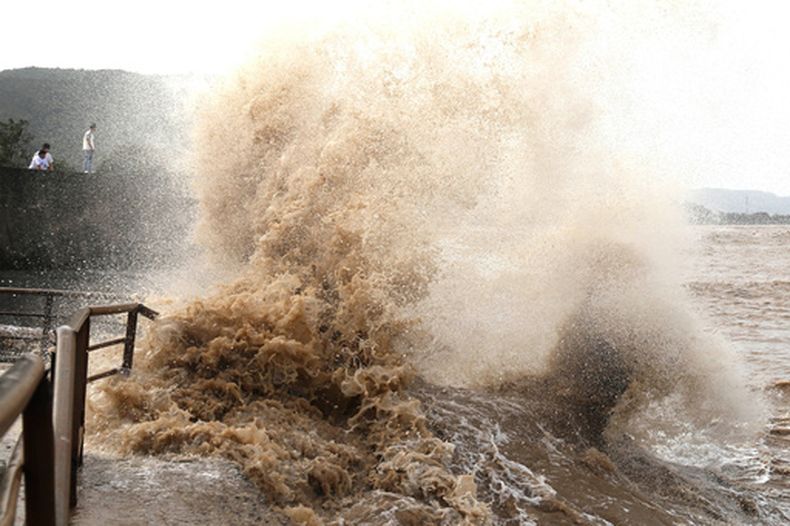 Fuertes olas chocan contra la costa antes de la llegada del tifón Bavi en Wenling en la provincia oriental china de Zhejiang, el viernes 10 de julio de 2026. (Chinatopix Via AP) CHINA NO