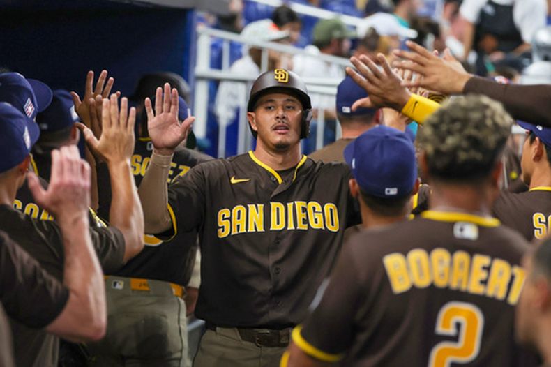 El dominicano Manny Machado, de los Padres de San Diego, festeja en la cueva tras anotar en un sencillo de Ty France ante los Marlins de Miami, el sábado 25 de julio de 2026 (AP Foto/David Santiago)
