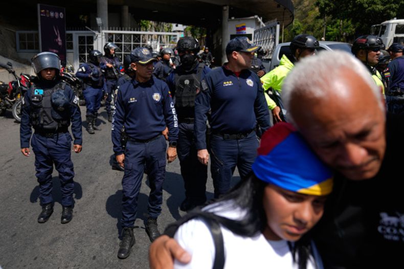 La policía permanece en alerta para impedir que la gente se acerque al centro de detención de Helicoide después de que la multitud participara en una oración por la libertad de los presos políticos, la paz y la reconciliación en Caracas, Venezuela, el sábado 7 de febrero de 2026. (Foto AP/Ariana Cubillos)