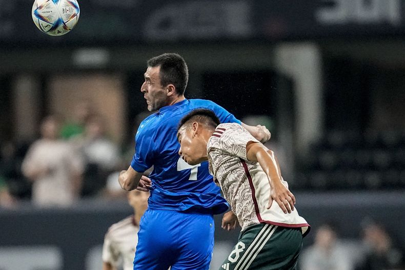 Farrux Sayfiev, defensa de Uzbekistán, remata frente a Carlos Rodríguez, de México, en un partido amistoso realizado el martes 12 de septiembre de 2023, en Atlanta (AP Foto/Mike Stewart)