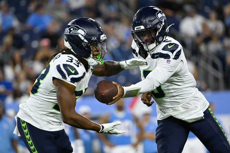 Jalen Milroe, quarterback de los Seahawks de Seattle, entrega el balón al corredor Velus Jones Jr., durante un partido de pretemporada ante los Titans de Tennessee, el domingo 23 de agosto de 2026 (AP Foto/John Amis)