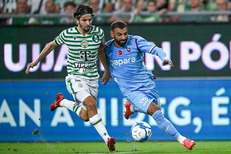 Mohamed Salah (derecha) de Trabzonspor y Adam Nagy de Ferencvaros disputan el balón en el partido de la Liga Europa, el jueves 27 de agosto de 2026, en Budapest. (Robert Hegedus/MTI vía AP)