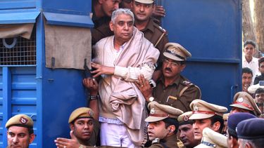 americateve | En la imagen, el controvertido gur&uacute; Rampal de pie en la puerta de un veh&iacute;culo policial mientras es trasladado a un tribunal, rodeado por agentes de la polic&iacute;a en Chandigarh, India, el 20 de noviembre de 2014. (Foto AP/Kapil Sethi)