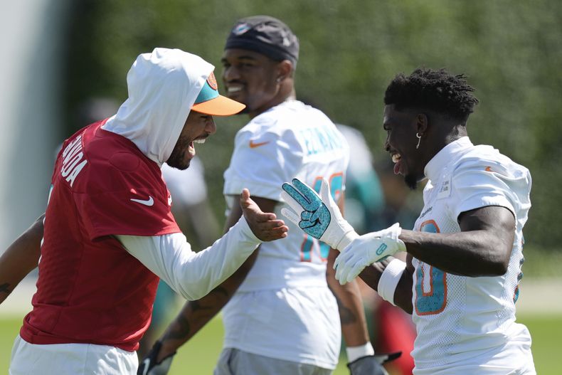 Tyreek Hill, derecha, wide receiver de los Dolphins de Miami, saluda al quarterback Tua Tagovailoa durante el entrenamiento del equipo de la NFL, el miércoles 11 de septiembre de 2024, en Miami Gardens, Florida. (AP Foto/Rebecca Blackwell)