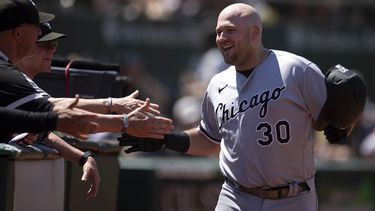 Jake Burger (30), de Medias Blancas de Chicago, es felicitado por sus compañeros de equipo después de batear cuadrangular solitario en contra de los Atléticos de Oakland durante la séptima entrada del juego de béisbol, el domingo 2 de julio de 2023, en Oakland, California. (AP Foto/D. Ross Cameron)