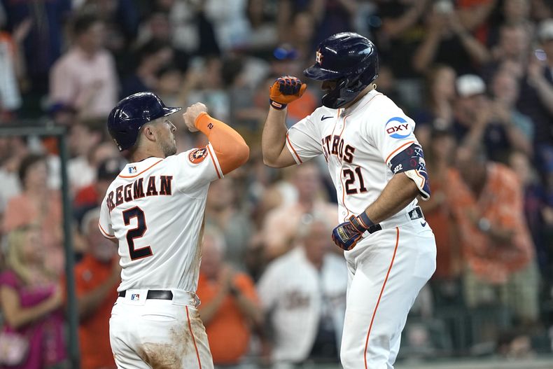El dominicano Yainer Díaz (21) y Alex Bregman (2) celebran mientras ambos anotaban para los Astros de Houston con el cuadrangular de Díaz ante los Mets de Nueva York, durante la cuarta entrada del juego de este miércoles 21 de junio de 2023, disputado en Houston. (AP Photo/David J. Phillip)
