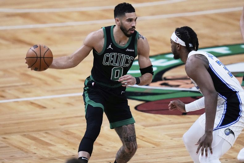 El alero de los Celtics de Boston, Jayson Tatum (0), conduce hacia la canasta contra el pívot del Magic de Orlando Wendell Carter Jr. (34) durante la primera mitad del Juego 5 de una serie de baloncesto de primera ronda de los playoffs de la NBA, el martes 29 de abril de 2025, en Boston. (AP Foto/Charles Krupa)