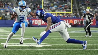 Hendon Hooker (2), quarterback de los Lions de Detroit, acarrea el balón en contra de Darrian Beavers (43), linebacker de los Giants de Nueva York, durante el tercer cuarto del juego de pretemporada de la NFL, el jueves 8 de agosto de 2024, en East Rutherford, Nueva Jersey. (AP Foto/Seth Wenig)