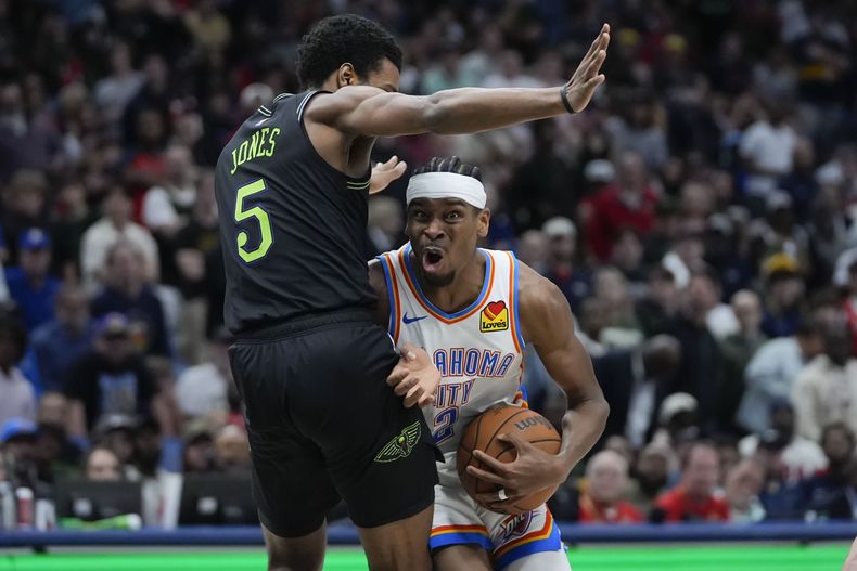 Shai Gilgeous-Alexander, del Thunder de Oklahoma City, trata de avanzar frente a Herbert Jones, de los Pelicans de Nueva Orleáns, el martes 26 de marzo de 2024 (AP Foto/Gerald Herbert)