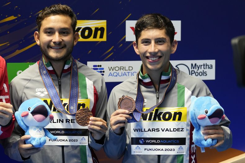 Los mexicanos Kevin Berlín y Randal Willars posan con sus medallas de bronce tras competir en la plataforma sincronizada de 10 metros en el Mundial de natación en Fukuoka, Japón, el lunes 16 de julio de 2023. (AP Foto/Lee Jin-man)