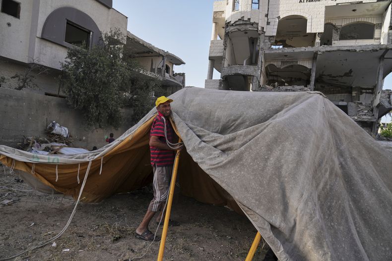 Neman Abu Jarad levanta una nueva tienda para su familia después de que fueran desplazados por la ofensiva aérea y terrestre israelí en la Franja de Gaza, en Ciudad de Gaza, el lunes 19 de mayo de 2025. (AP Foto/Jehad Alshrafi)