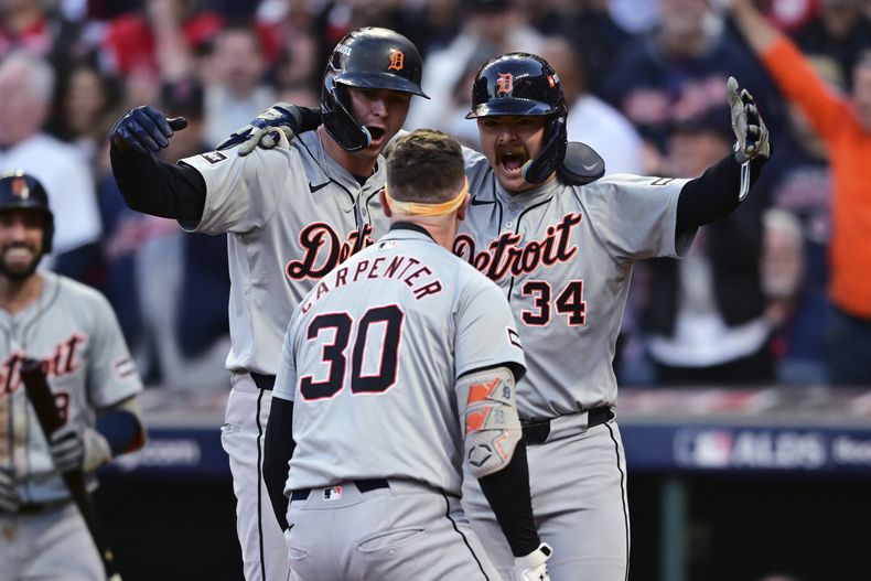 Trey Sweeney (27) y Jake Rogers, de los Tigres de Detroit, esperan en el plato a su compañero de equipo Kerry Carpenter (30) después de que Carpenter conectó un jonrón de tres carreras en la novena entrada durante el Juego 2 de la Serie Divisional de la Liga Americana de béisbol contra los Guardianes de Cleveland, el lunes 7 de octubre de 2024, en Cleveland. (AP Foto/David Dermer)