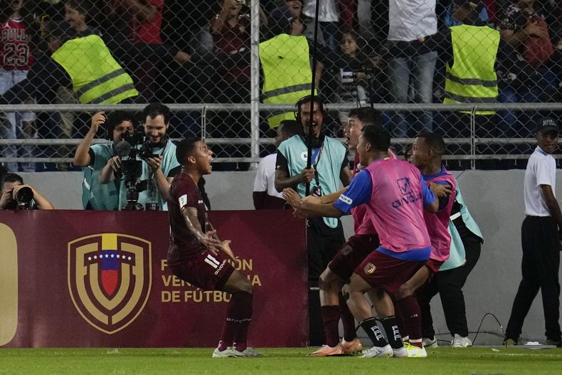 Darwin Machis (izquierda) festeja con sus compañeros de la selección de Venezuela tras anotar ante Chile en un encuentro de las eliminatorias al Mundial, el martes 17 de octubre de 2023, en Maturín (AP Foto/Ariana Cubillos)