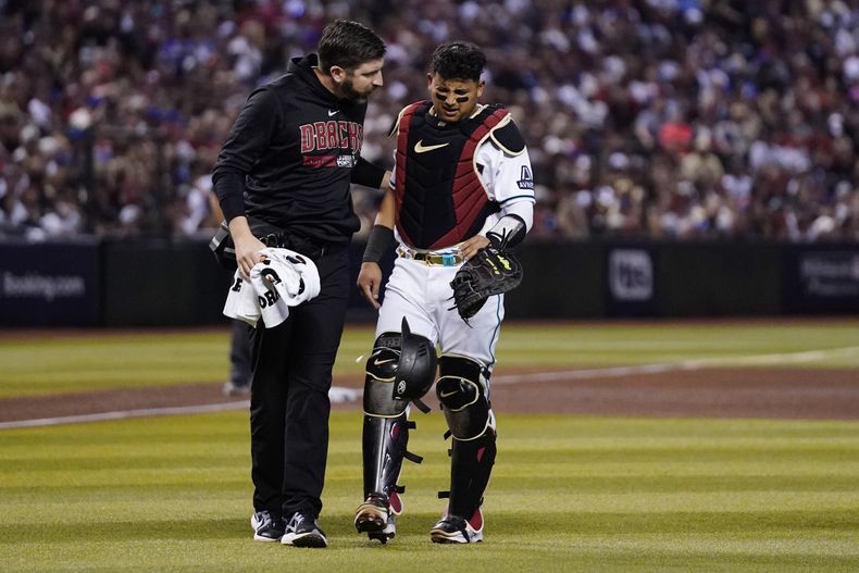 Un kinesiólogo atiende al venezolano Gabriel Moreno, cátcher de los Diamondbacks de Arizona, quien se lastimó una mano en el tercer juego de la serie divisional de la Liga Nacional ante los Dodgers de Los Ángeles (AP Foto/Ross D. Franklin)