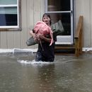 Un hombre carga objetos personales por una zona inundada desde una casa en Bridgewater, Vermont, el lunes 10 de julio de 2023. Las fuertes lluvias anegaron zonas del nordeste de Estados Unidos, donde destruyeron carreteras, forzaron evacuaciones y paralizaron parte del tráfico aéreo. (AP Foto/Hasan Jamali)