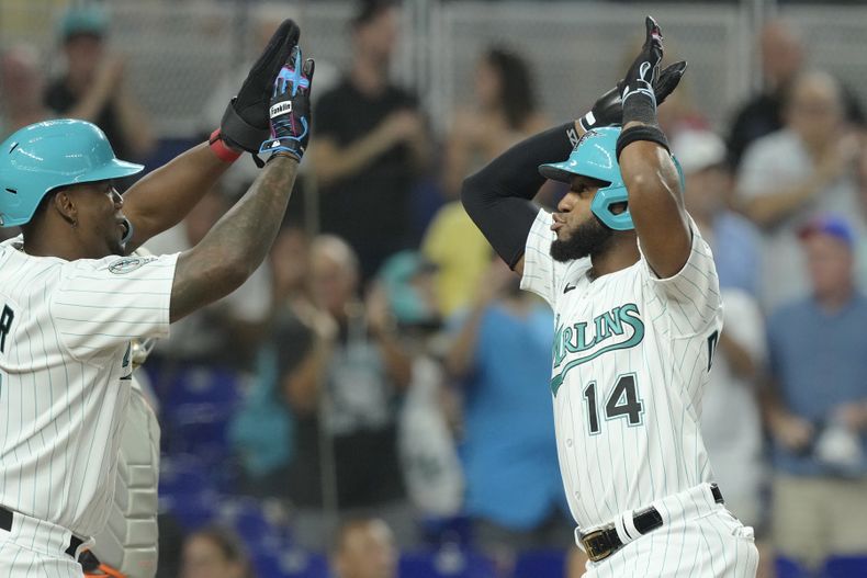 Bryan De La Cruz (14), de los Marlins de Miami, celebra su cuadrangular de dos carreras con Jorge Soler durante la primera entrada del juego de béisbol en contra de los Tigres de Detroit, el viernes 28 de julio de 2023, en Miami. (AP Foto/Marta Lavandier)
