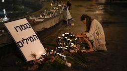 Una mujer enciende una vela en honor a las víctimas del ataque de Hamas durante una vigilia en Dizengoff en el centro de Tel Aviv el viernes 13 de octubre del 2023. (AP Foto/Francisco Seco)