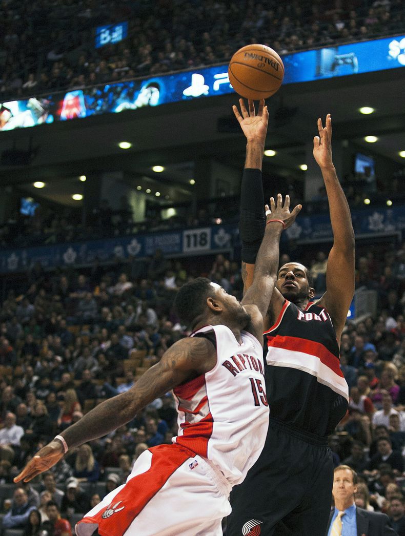LaMarcus Aldridge, de los Trail Blazers de Portland, tira sobre Amir Johnson, de los Raptors de Toronto, durante su juego del domingo 17 de noviembre de 2013, en Toronto. (Foto AP/The Canadian Press, Aaron Vincent Elkaim)