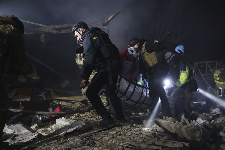 Agentes de policía trasladan el cuerpo de una persona fallecida en un ataque con drones rusos en un vecindario residencial de Zaporiyia, Ucrania, el 21 de marzo de 2024. (AP Foto/Kateryna Klochko)