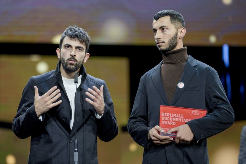 El palestino Basel Adra (d) y el israelí Yuval Abraham reciben el premio por su película No Other Land en el Festival de Cine Berlinale, en Berlín, el 24 de febrero del 2024. (AP foto/Markus Schreiber)