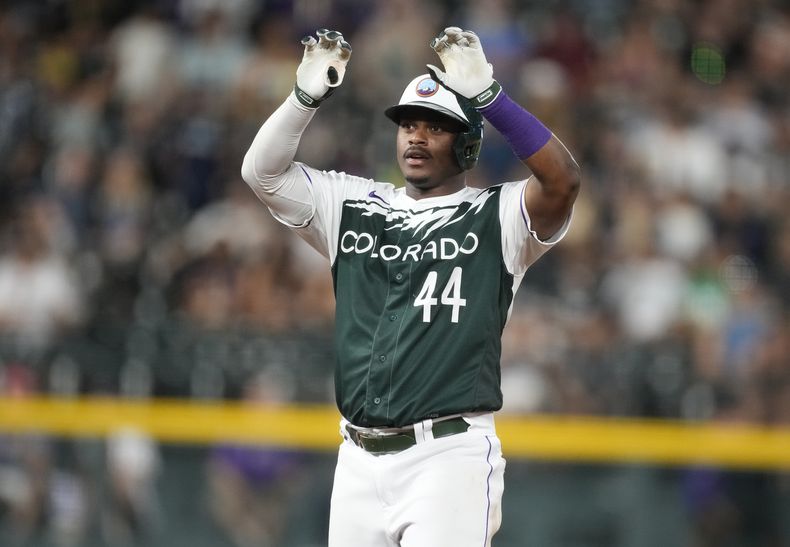 El dominicano Elehuris Montero, de los Rockies de Colorado, festeja luego de conseguir un doble de dos carreras ante los Medias Blancas de Chicago, el sábado 19 de agosto de 2023 (AP Foto/David Zalubowski)