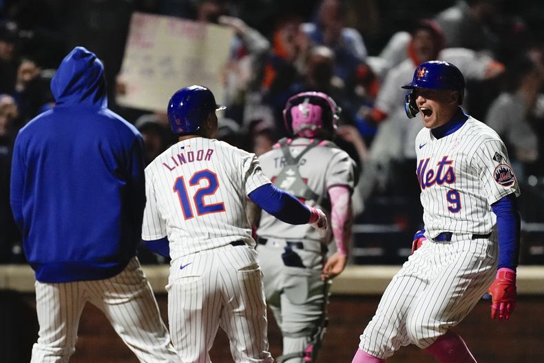 Brandon Nimmo (9) de los Mets de Nueva York celebra junto al boricua Francisco Lindor (12) y otros compañeros de equipo luego de sacudir el jonrón de dos carreras que definió en la novena entrada el juego ante los Bravos de Atlanta, el domingo 12 de mayo de 2024, en Nueva York. (AP Foto/Julia Nikhinson)
