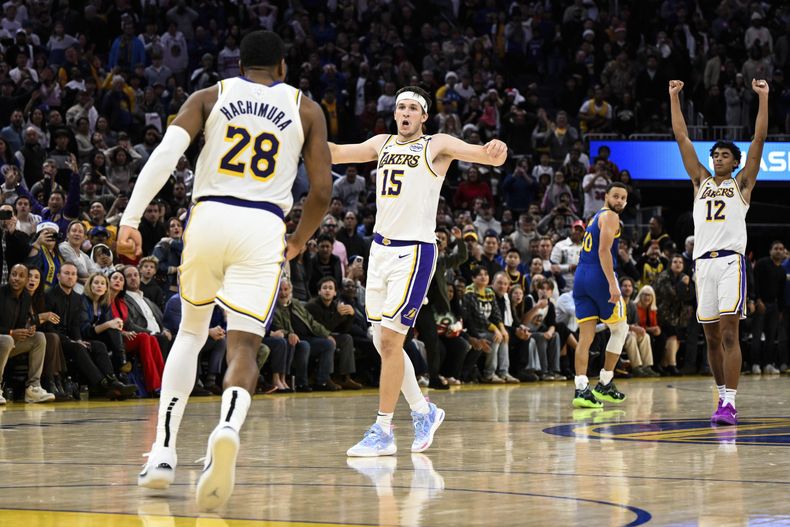 Austin Reaves (15), base de los Lakers de Los Ángeles, festeja con sus compañeros Rui Hachimura (28) y Max Christie, tras asegurar el triunfo sobre los Warriors de Golden State, el miércoles 25 de diciembre de 2024 (AP Foto/Eakin Howard)