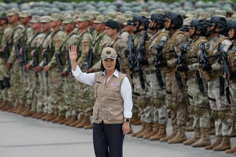 La presidenta de Perú, Keiko Fujimori, saluda a la prensa tras anunciar la creación de un equipo de élite contra la delincuencia, formado por agentes de policía y militares, en una base militar de Lima (Perú), el miércoles 7 de octubre de 2026. (Foto AP/Martín Mejía).