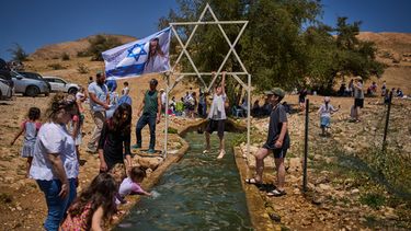 Un niño se cuelga en una estructura metálica con forma de estrella de David sobre un manantial en Auja, en el valle del Jordán, durante el Día de la Independencia de Israel, el 22 de abril de 2026, en la Cisjordania ocupada. (AP Foto/Ohad Zwigenberg)