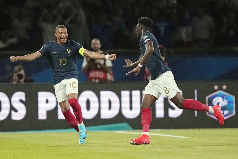 Aurélien Tchouaméni (derecha) y Kylian Mbappé (10) celebran el gol de Tchouamén ante Irlanda por las eliminatoria de la Eurocopa, el jueves 7 de septiembre de 2023, en el Parc des Princes en París. (AP Foto/Michel Euler)