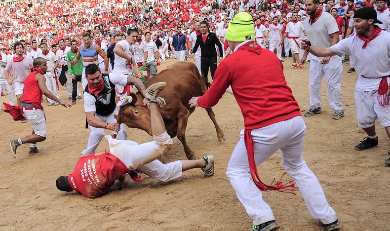 Un partyidipante es golpeado por un toro en la plaza de toros de Pamplona en la fiesta de San Ferm&iacute;n, en Pamplona, Espa&ntilde;a, el martes, 8 de julio del 2014. (Foto AP/Alvaro Barrientos)