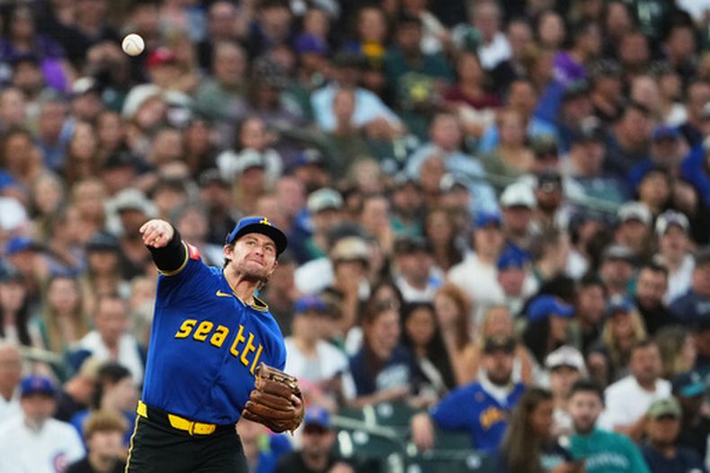 El jugador de los Marineros de Seattle, Brendan Donovan, hace un tiro a la primera base tras un sencillo del jugador de los Cachorros de Chicago, Alex Bregman, cometiendo un error de tiro y permitiendo que Seiya Suzuki, de los Cachorros, llegue a tercera base durante la tercera entrada de un partido de béisbol, el viernes 21 de agosto de 2026, en Seattle. (Foto AP/Lindsey Wasson)