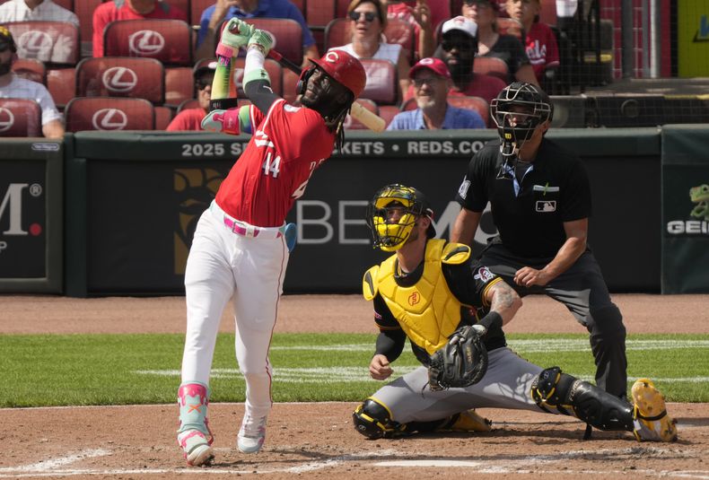 Elly De La Cruz de los Rojos de Cincinnati observa su jonrón de tres carreras frente al cátcher de los Piratas de Pittsburgh Yamsani Grandal y el umpire Charlie Ramos en el encuentro del sábado 21 de septiembre del 2024. (AP Foto/Carolyn Kaster)