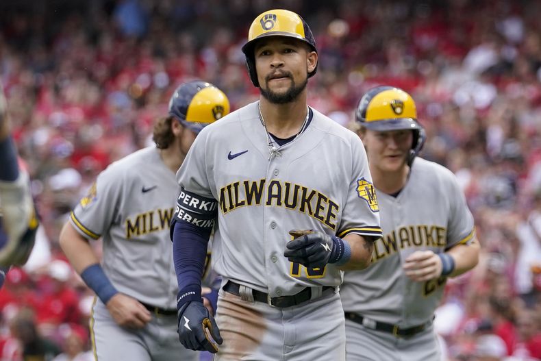 ARCHIVO - Blake Perkins, centro, de los Cerveceros de Milwaukee, celebra con sus compañeros de equipo después de conectar un grand slam contra los Rojos de Cincinnati en la tercera entrada de un juego de béisbol en Cincinnati, el sábado 3 de junio de 2023. (AP Foto/Jeff Dean, Archivo)