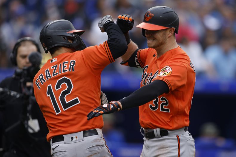 Ryan OHearn festeja su jonrón de tres carreras con Adam Frazier, de los Orioles de Baltimore, en un juego ante los Azulejos de Toronto, el sábado 20 de mayo de 2023 (Cole Burston/The Canadian Press via AP)