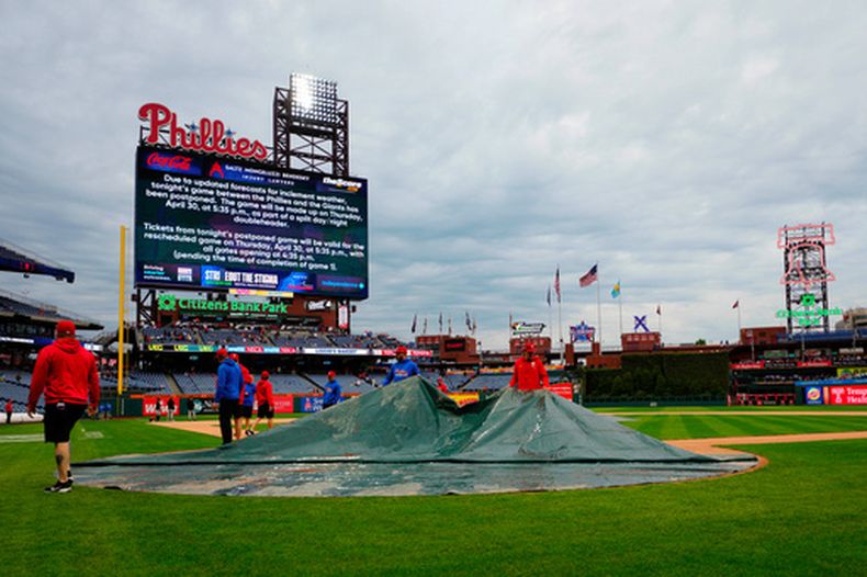Personal de mantenimiento cubre el campo después de que se pospusiera un partido de béisbol entre los Filis de Filadelfia y los Gigantes de San Francisco, el miércoles 29 de abril de 2026, en Filadelfia. (Foto AP/Derik Hamilton)