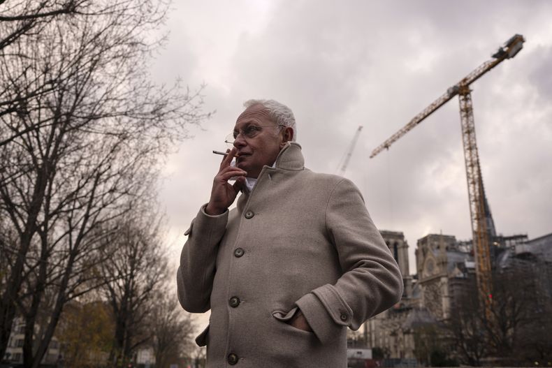 El arquitecto jefe de la Catedral de Notre Dame de París, Philippe Villeneuve, fuma un cigarrillo durante una entrevista con The Associated Press, el martes 3 de diciembre de 2024, en París. (AP Foto/Louise Delmotte)