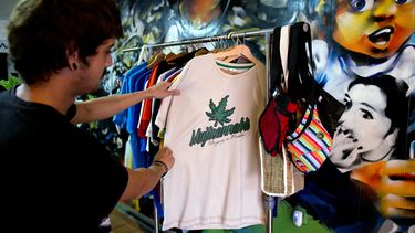 americateve | Un cliente observa una camiseta decorada con una hoja de marihuana y la palabra "Mujicannabis" en una tienda de Montevideo, Uruguay, martes 6 de mayo de 2014. El presidente Jos&eacute; Mujica firm&oacute; en la fecha la ley de reglamentaci&oacut